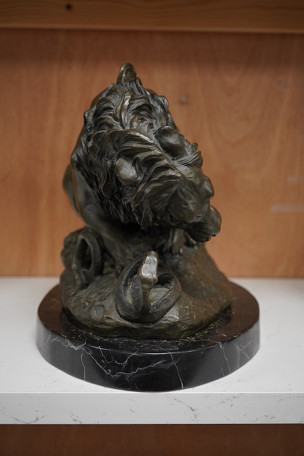 A patinated bronze group of a lion and snake, J.B Paris foundry stamp, signed Coreira, on a black marble base, 23cm high